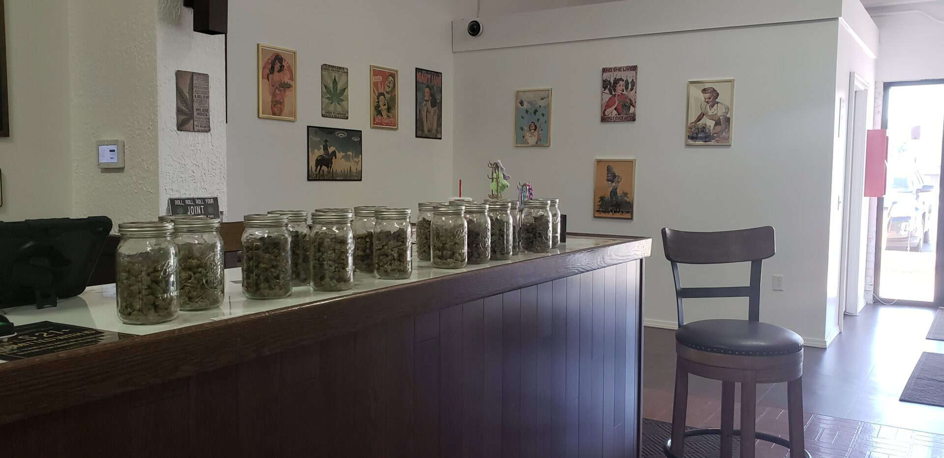 Cannabis jars on a wooden counter in a dispensary.