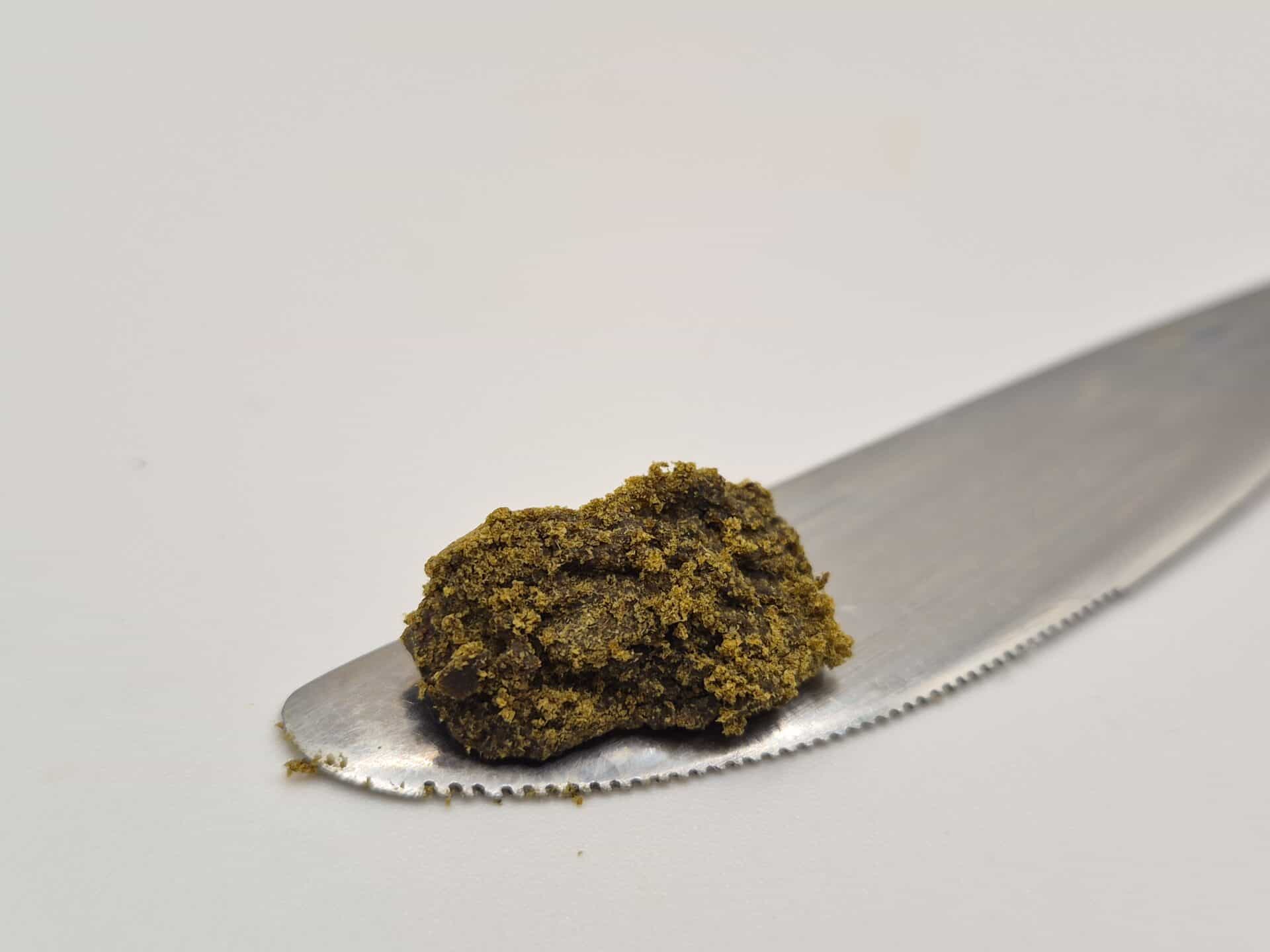 Crumbly brown substance on serrated metal knife