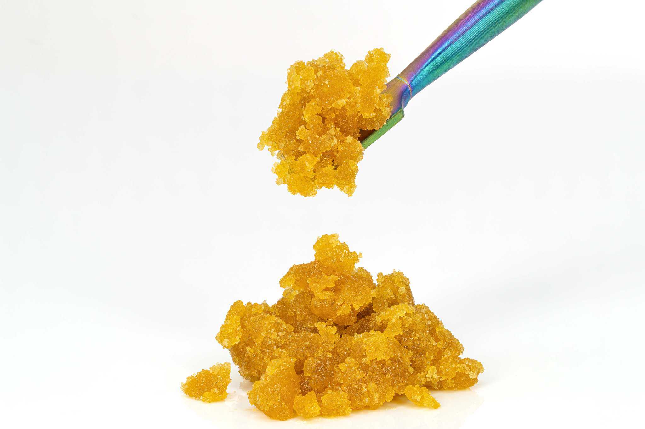 Golden cannabis concentrate with dabbing tool