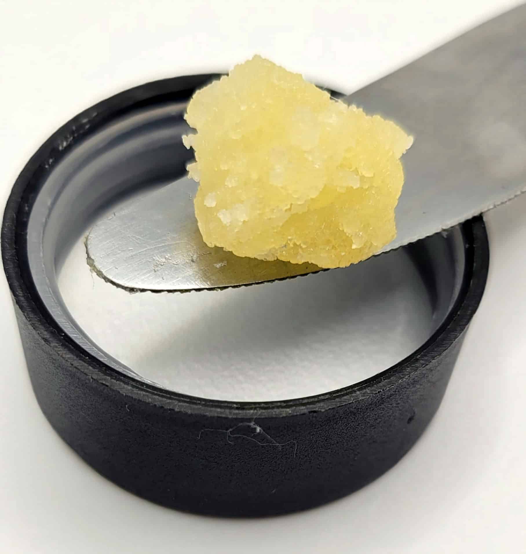 Yellow dab of cannabis concentrate on metal tool.
