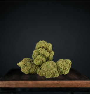 Dried cannabis buds on wooden surface, dark background