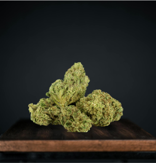 Cannabis buds on wooden surface against dark background