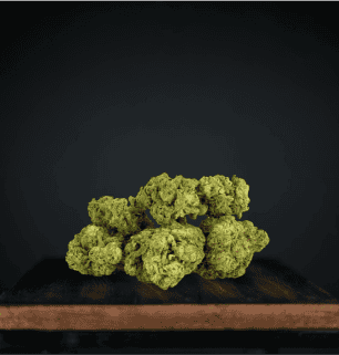 Green broccoli florets on dark wooden surface