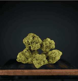 Cannabis buds on wooden surface against dark background