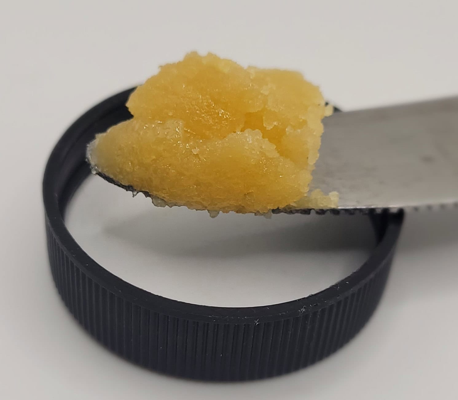 Yellow aromatic paste on a knife blade.