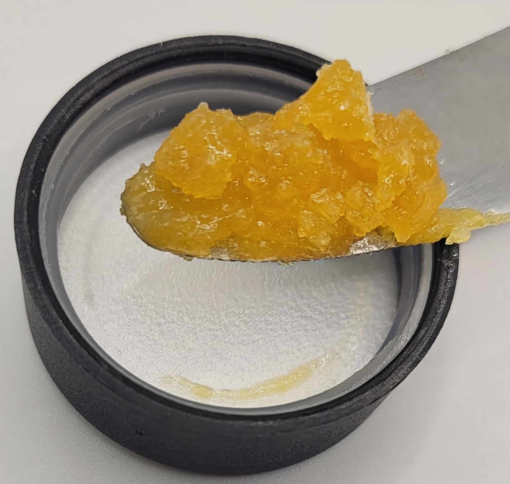 Yellow substance on metal spatula in jar