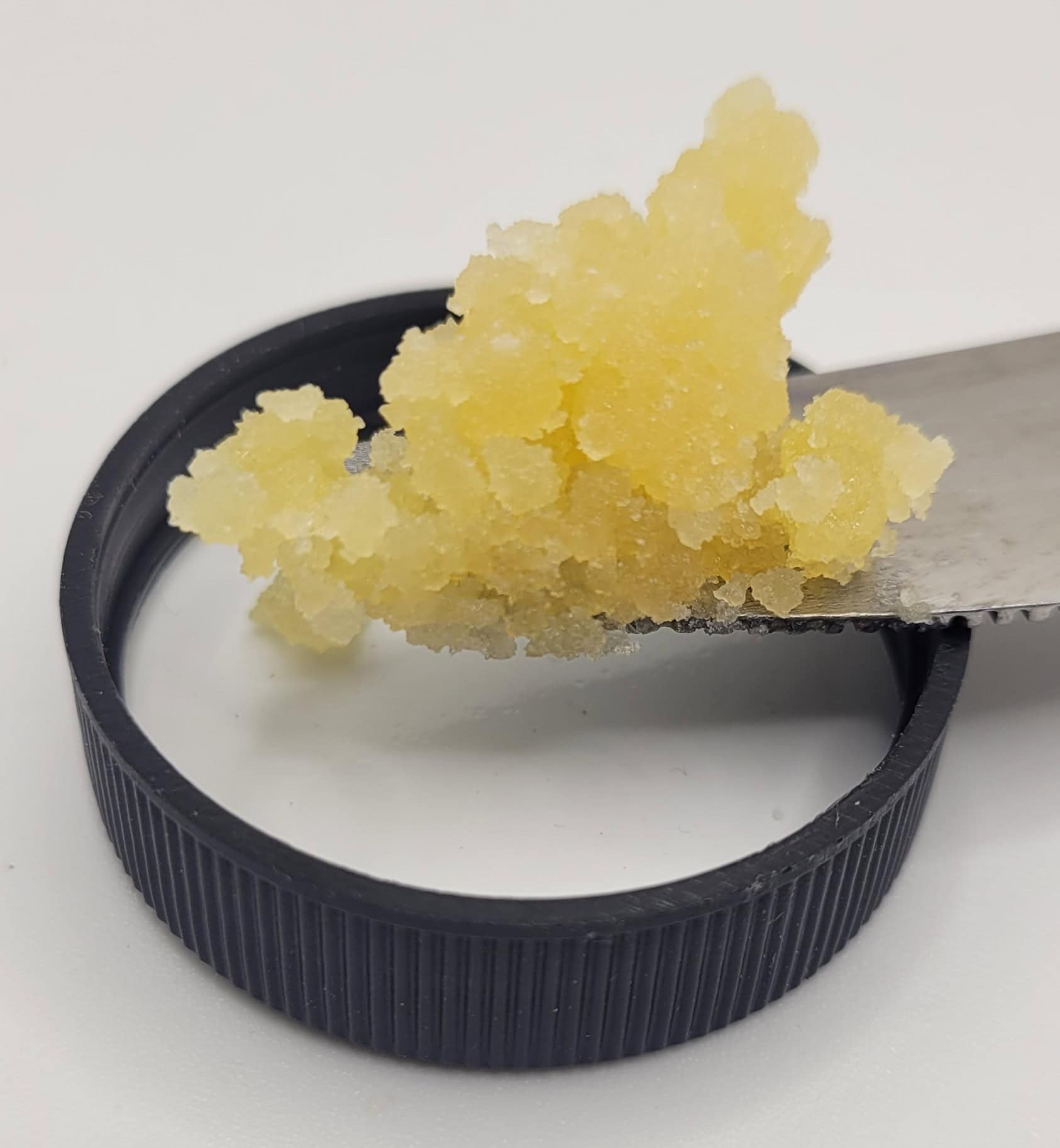 Yellow sugar scrub on black cap and knife