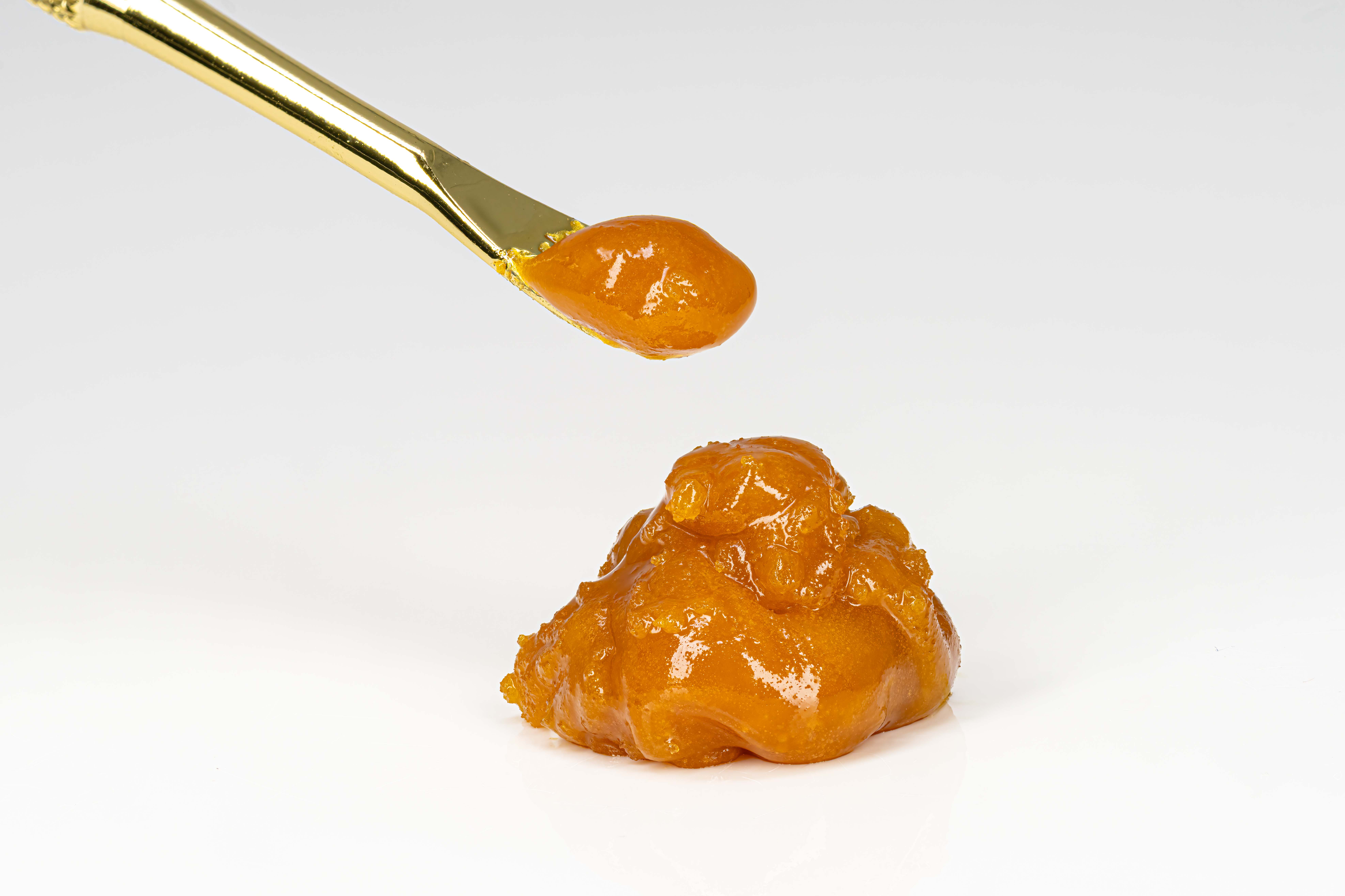 Golden honey on spoon and surface
