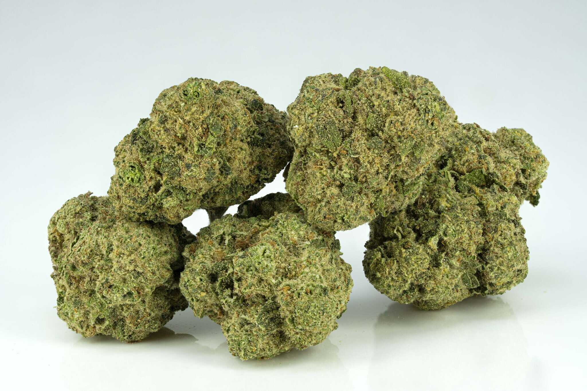 Stack of cannabis buds on white background.