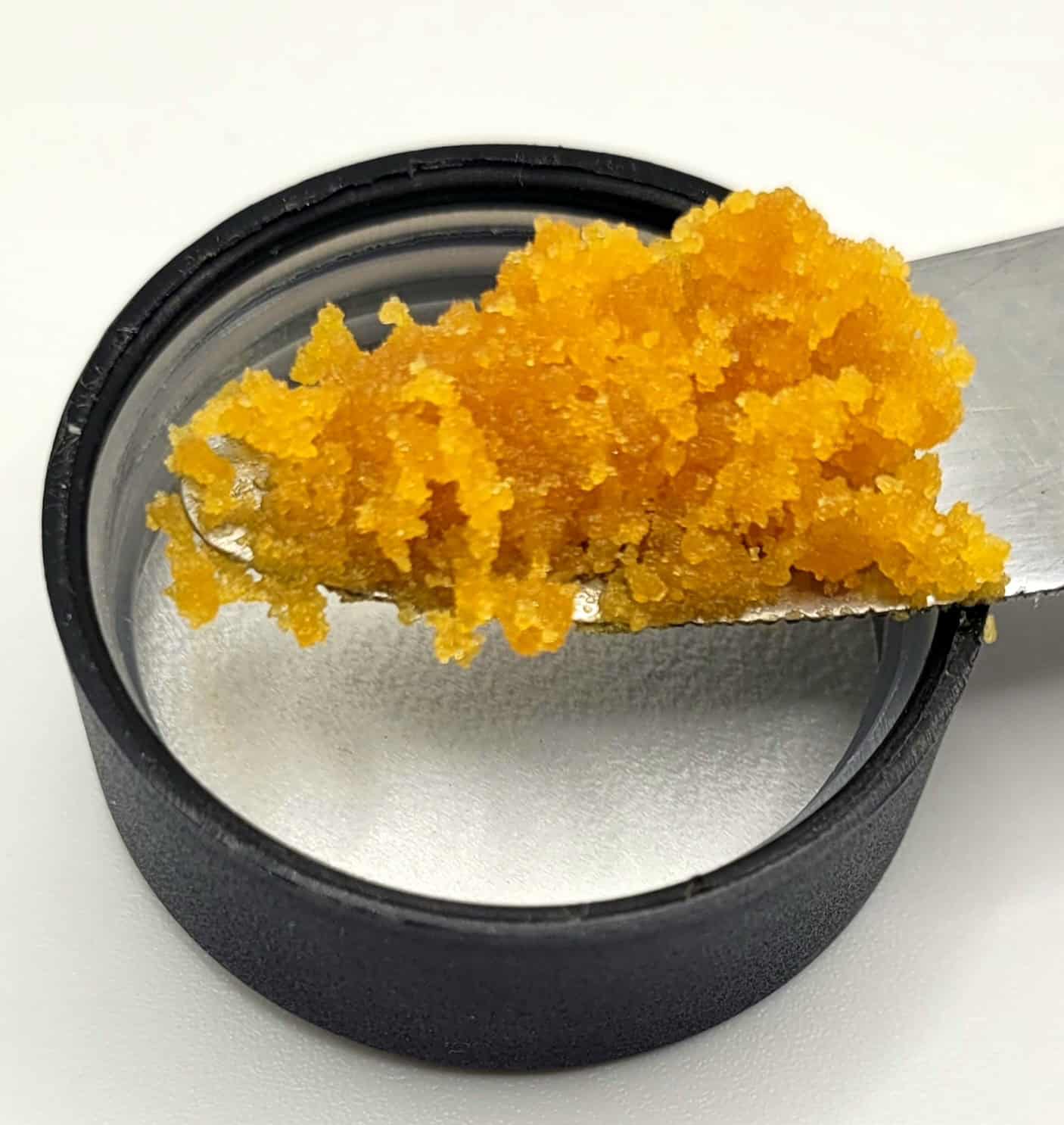 Orange cannabis concentrate on metal tool