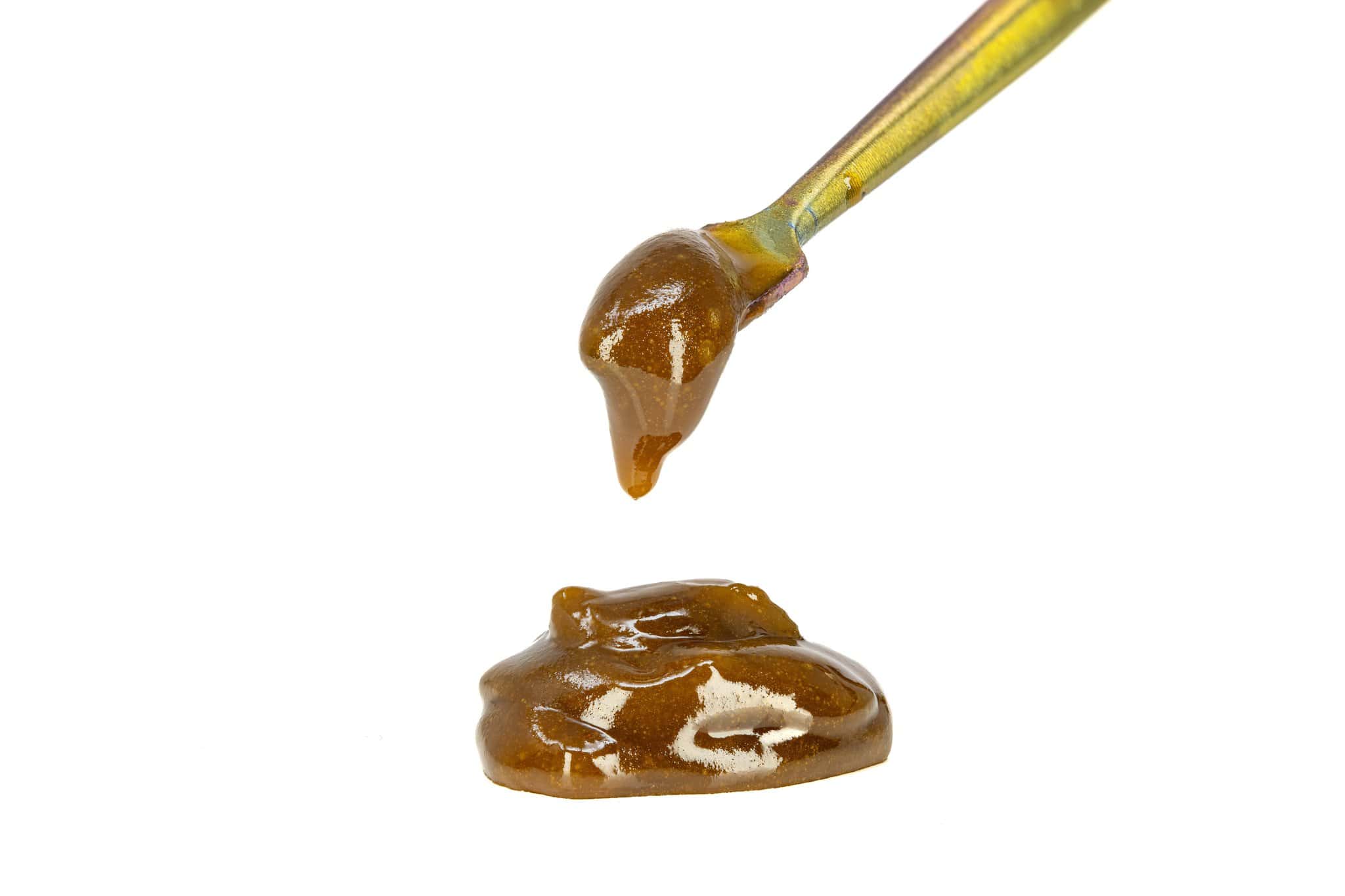 Dripping golden honey from spoon isolated on white