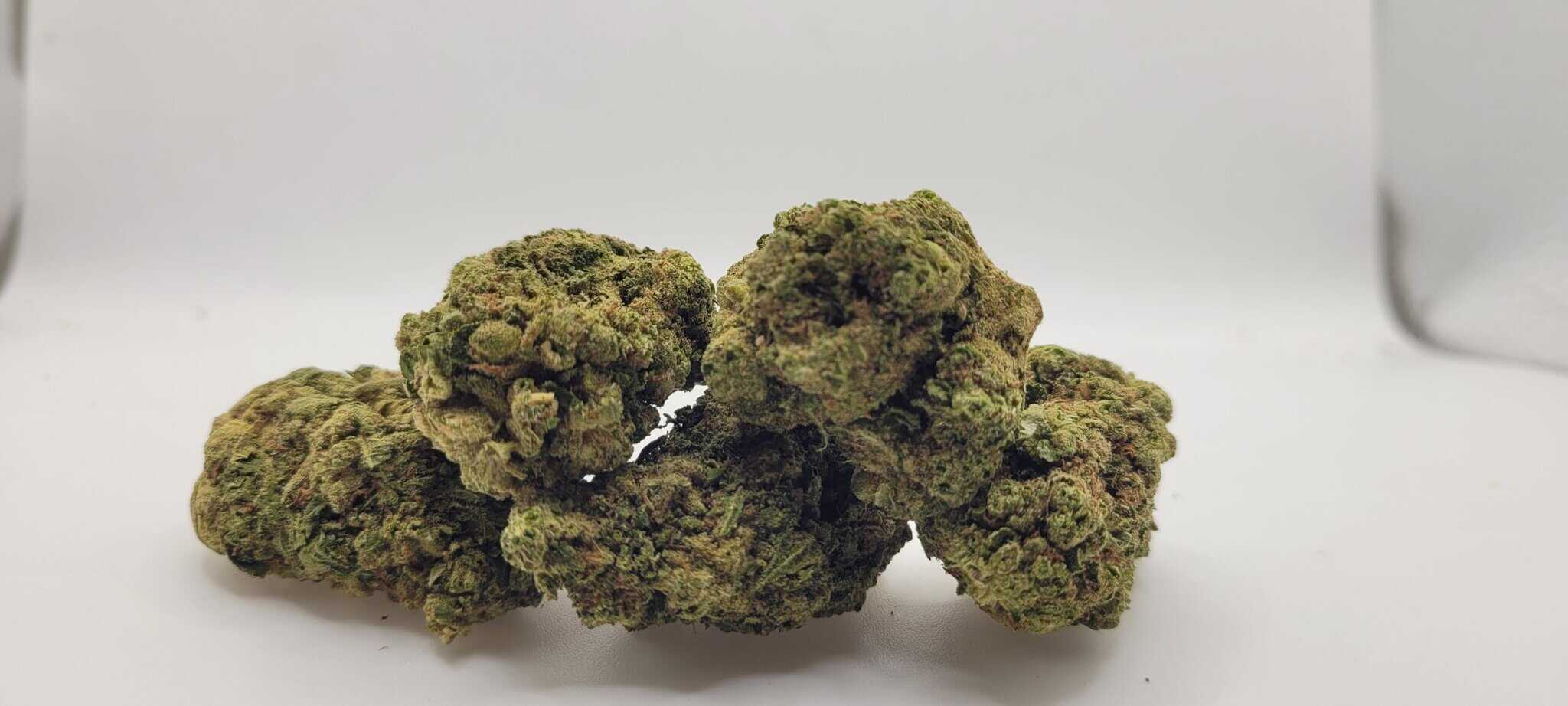 Close-up of dried cannabis buds on white background.