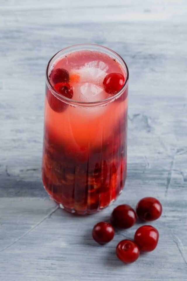 Refreshing cherry cocktail with ice cubes in a glass