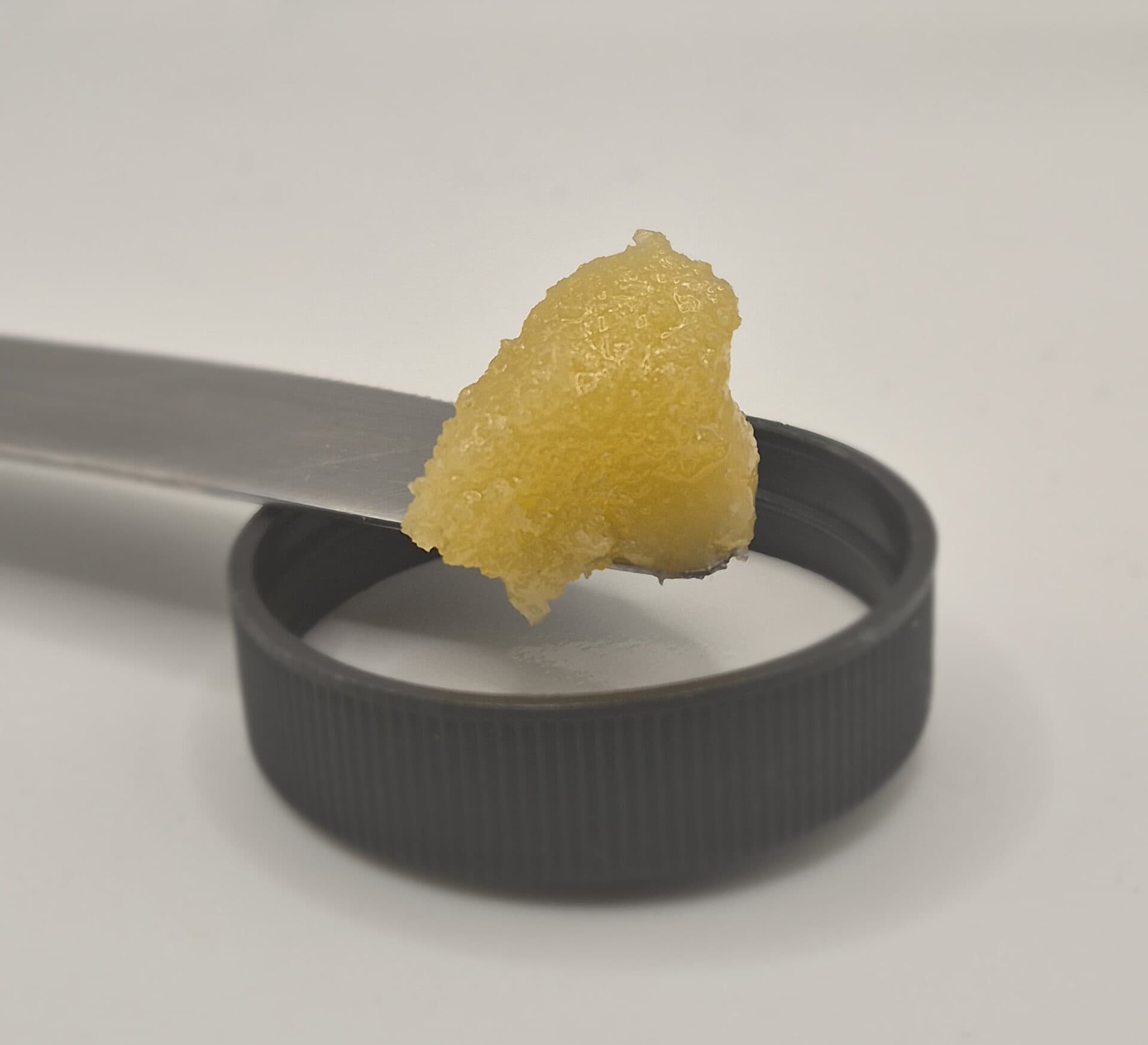 Close-up of yellow wax concentrate on metal tool