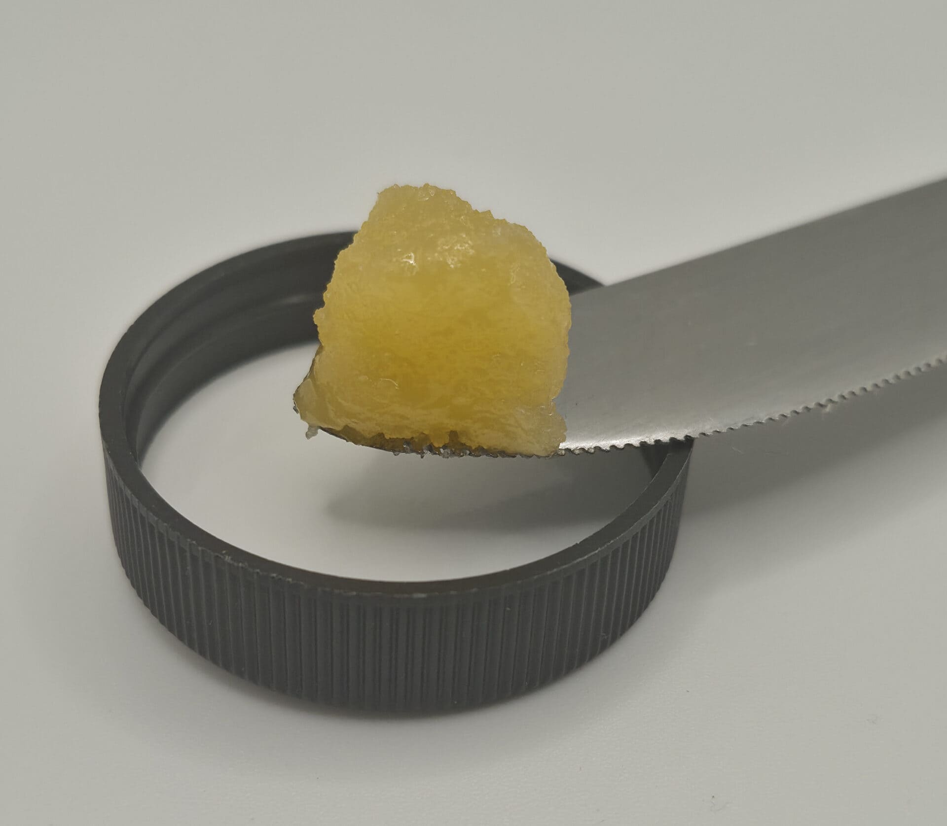 Small yellow fruit chunk on serrated knife